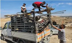  ?? Photograph: Bethan McKernan/The Guardian ?? Zanuta residents load their belongings on to a pickup truck after deciding they have lost the fight to remain on their land.