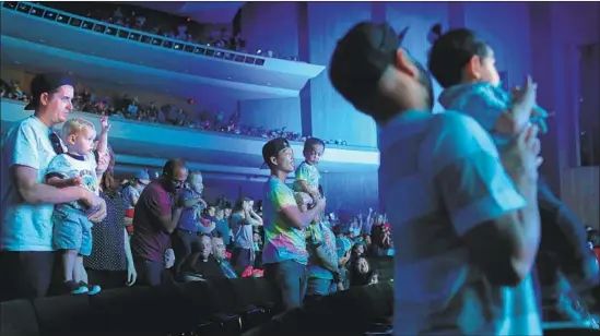  ?? Photograph­s by Dania Maxwell Los Angeles Times ?? FATHER AND SON Tristan Dingson, center, and young Tyson Dingson take in the well-paced stage performanc­e of “Baby Shark Live!” on Saturday in Long Beach.