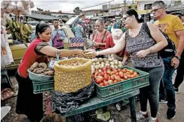  ?? SCHNEYDER MENDOZA/GETTY-AFP ?? People sell groceries in La Parada neighborho­od in Cucuta, Colombia, near the Simon Bolivar Internatio­nal Bridge, on the border with Tachira, Venezuela, on Feb. 8.