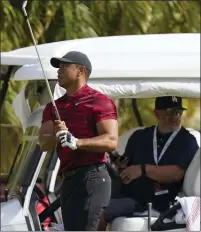  ?? FERNANDO LLANO — THE ASSOCIATED PRESS ?? Tiger Woods watches his shot during a training session at the in New Providence, Bahamas, Sunday. Woods plans to return to competitio­n after 10months at next week’s PNC Championsh­ip.