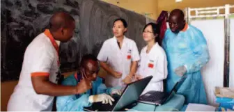  ??  ?? Zhou Yujie often encourages students and doctors to participat­e in medical aid missions abroad. This picture shows his postdoctor­al student Liu Xiaoli (center) providing epidemic survey training to local medical workers during a medical aid mission to fight Ebola in the Republic of Guinea in Africa.