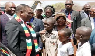  ??  ?? President Mnangagwa chats to three boys who were among the VIPs who received him on his arrival for the Lupane State University graduation ceremony at Somhlolo Stadium in Lupane on Friday. Looking on (left) is Minister for Matabelela­nd North Provincial Affairs Cde Richard Moyo (Picture by Eliah Saushoma)