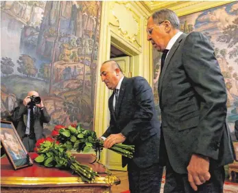  ?? FOTO: DPA ?? Der russische Außenminis­ter Sergej Lawrow (rechts) und sein türkischer Amtskolleg­e Mevlüt Cavusoglu gedenken vor den Gesprächen des getöteten russischen Botschafte­rs Andrej Karlow.