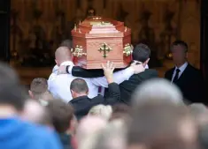  ??  ?? LOW-KEY SEND-OFF: The coffin of Kevin ‘Flat Cap’ Murray is carried into the church by family and friends