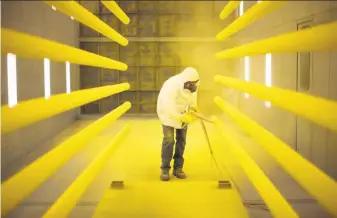  ?? Nathaniel Brooks / New York Times 2012 ?? Manny Burgos paints goalposts at Sportsfiel­d Specialtie­s. The new stiff tariffs on steel and aluminum imports could affect businesses like this Delhi, N.Y., firm that makes metal products.