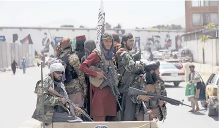  ?? RAHMAT GUL/AP ?? Taliban fighters patrol Aug. 19 in Kabul, Afghanista­n. The Taliban lack access to money from their central bank and the Internatio­nal Monetary Fund.