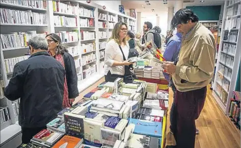  ?? LLIBERT TEIXIDO ?? Lectores buscando entre las estantería­s en la librería Jaimes durante la mañana de Sant Jordi