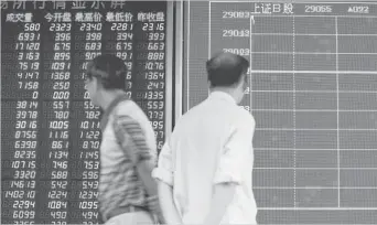  ?? ASSOCIATED PRESS ?? People walk while monitoring stock prices at a brokerage house in Beijing, Monday, June 25, 2018. Asian stock markets fell Monday and oil prices gave up some of their gains after Chinese regulators freed up extra money for bank lending amid a trade...