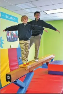  ??  ?? Brothers Chase (front) and Cooper (back) Pellett walk on the balance beam at The Little Gym of Saratoga.