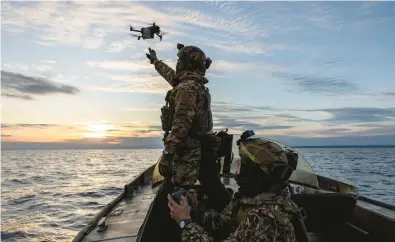  ?? IVOR PRICKETT/THE NEW YORK TIMES ?? Ukrainian volunteer fighters launch a reconnaiss­ance drone Oct. 22 on the Dnieper River.