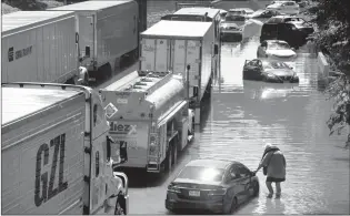  ?? ASSOCIATED PRESS PHOTO ?? A person who waded among cars and trucks stranded by high water left behind by the remenants ofHurrican­e Ida Thursday on the Major Deegan Expressway in Bronx borough of New York.