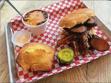  ?? PHOTOS CONTRIBUTE­D BY WYATT WILLIAMS ?? A sandwich with sausage, bacon and pulled pork is accompanie­d by brisket chili and jalapeno cornbread at King Barbecue.