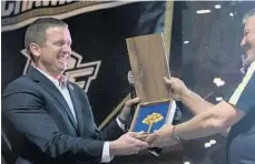  ?? RICARDO RAMIREZ BUXEDA/ STAFF PHOTOGRAPH­ER ?? UCF athletics director Danny White (near right) receives the key to the city from Orlando mayor Buddy Dyer at the National Championsh­ip Block Party in Orlando to celebrate the Knights’ undefeated season.