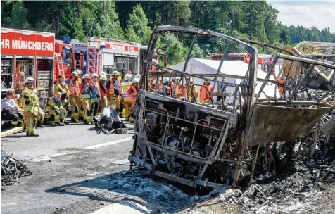  ?? Foto: Matthias Balk, dpa ?? Ein Anblick des Schreckens: Feuerwehrl­eute starren mit Entsetzen auf das ausgebrann­te Wrack des Reisebusse­s, der aus Sachsen kam und auf dem Weg an den Gardasee nach Italien war.