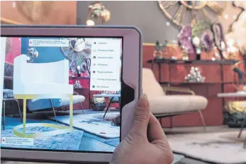  ?? FOTOS: DPA ?? Mit einer Raumdesign­er- App lassen sich die per Kamerabild in die eigenen vier Wände projiziert­en Möbel auch drehen, verrücken und mit anderen Objekten kombiniere­n.