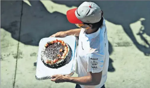  ??  ?? Carlos Sainz sujeta la tarta de cumpleaños que le regaló McLaren ayer en el circuito de Monza para celebrar los 26 años que cumplió el martes.