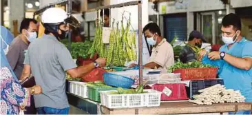  ??  ?? ORANG ramai memakai pelitup muka ketika membeli barang keperluan harian di Pasar Besar Alor Setar.