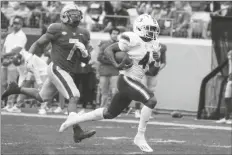  ?? KEITH SRAKOCIC/AP ?? MIAMI RUNNING BACK JAYLAN KNIGHTON (4) runs past Pittsburgh linebacker SirVocea Dennis (7) on his way to a long touchdown run during the first half of a game Saturday in Pittsburgh.