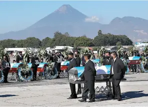  ?? AP Photo/Moises Castillo ?? Flag draped coffins carrying the remains of Guatemalan migrants who were killed near the U.S.-Mexico border in January arrive Friday at the Air Force base in Guatemala City. The migrants were among 19 people shot and burned in Camargo, located in the northern Mexican state of Tamaulipas on Jan. 22.