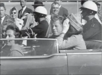  ?? JIM ALTGENS — THE ASSOCIATED PRESS FILE ?? In this file photo, President John F. Kennedy waves from his car in a motorcade in Dallas. Riding with Kennedy are First Lady Jacqueline Kennedy, right, Nellie Connally, second from left, and her husband, Texas Gov. John Connally, far left. The...