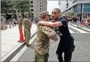  ?? AP- Alex Brandon, File ?? In this June 6 file photo, a demonstrat­or hugs a National Guard soldier during a protest in Washington, over the death of George Floyd. The National Guard has designated military police units in two states to serve as rapid reaction forces in order to be better prepared to respond quickly to civil unrest.