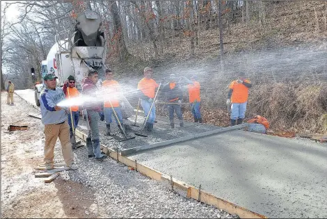  ?? NWA Democrat-Gazette/FLIP PUTTHOFF ?? Workers pour concrete March 4 along the pedestrian-bicycle trail being built around Lake Atalanta.