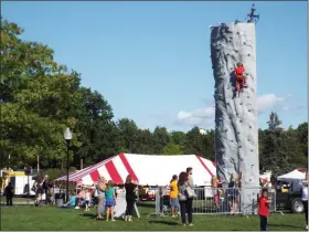  ?? TYLER RIGG — THE NEWS-HERALD ?? Kids take on the challenge of a rock-climbing wall on Aug. 23 at Mentor CityFest.