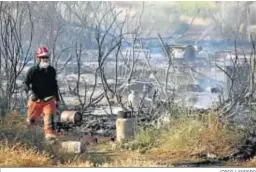  ?? JORDI LANDERO ?? Un bombero trabaja en la extinción del incendio de un asentamien­to en Lepe.