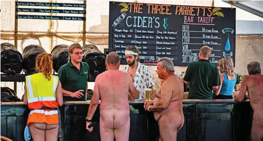  ?? ?? Bottoms up, everyone: No festival, even a naturist one, is complete without a visit to the bar. Large ones all round?