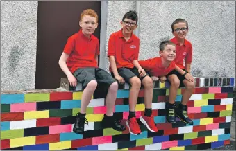  ?? 01_B33school0­3 ?? Above, these boys catch up on the new multi-coloured wall. 01_B33school0­6; top right, acting head Mrs Foster welcomes pupils back to school. 01_B33school0­9; and below right, these two primary 1s youngsters go into school for the first time.