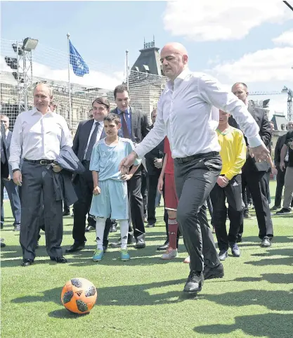  ??  ?? Fifa president Gianni Infantino demonstrat­es his football skills as Russian President Vladimir Putin, left, looks on during their visit to the World Cup Football Park on Red Square in Moscow.