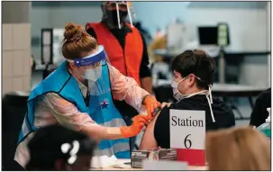  ?? (AP/Eric Gay) ?? A health care worker administer­s a covid-19 vaccinatio­n Monday at the Alamodome in San Antonio. Officials say the site is providing 1,500 vaccinatio­ns per day.