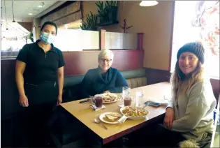  ?? NEWS PHOTO ?? Being allowed to resume restaurant dine-in services Monday was something to celebrate for Humpty’s Family Restaurant owner Katherine Raneses (left). Some of the returning regular customers included Dorothy Kurpjuweit and her daughter Christine who are enjoying breakfast.