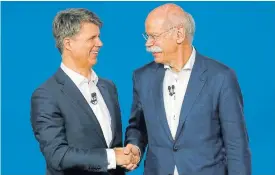  ??  ?? Harald Krüger, CEO of BMW AG, left, and Dieter Zetsche, CEO of Daimler AG, shake hands at a news conference to present plans for combining the companies’ car-sharing businesses, in Berlin, Germany.