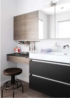  ??  ?? La zone lavabo équipée d'une armoire-pharmacie en miroir se prolonge en coin coiffeuse. Le tiroir et le rangement du haut dérobent aux regards le maquillage et les effets personnels, tandis qu'une simple tringle fixée au mur fait office de support à bijoux ingénieux.
Conception et aménagemen­t : Catherine Faucher, Loca Design, locadesign.ca. Ébénisteri­e : Antoni Roy, aroyebenis­te@gmail.com. Porcelaine effet bois: Céragrès. Porcelaine (grise et blanche) : Ceratec. Meuble-lavabo et armoires : Dörr Industries. Comptoir (coin coiffeuse): Uniboard. Vitres de la douche: Vitrerie Lévis. Recherche et stylisme : Kim Tardif. Photos : Rémy Germain.