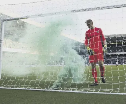  ??  ?? 0 Hearts’ Zdenek Zlamal approaches a flare in his net and, below, anti-neil Lennon graffiti on a wall near Tynecastle.