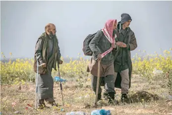  ??  ?? Civilians who streamed out of the IS group’s last Syrian stronghold walk towards a screening point for new arrivals run by Us-backed Syrian Democratic Forces outside Baghouz in the eastern Syrian Deir Ezzor province. — AFP