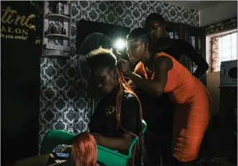  ?? PHOTOS: TOM SAATER — THE NEW YORK TIMES ?? In Lagos, Nigeria, stylists at a salon that can't find affordable fuel for a gas-powered generator turn to their cellphones for light. A spike in energy prices is having a cascading effect around the world.