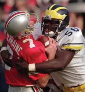  ?? ASSOCIATED PRESS FILE ?? Ohio State quarterbac­k Joe Germaine is sacked by Michigan defender James Hall during the third quarter of the Wolverines’ upset of the Nov. 2 Buckeyes in 1996 in Columbus.