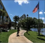  ?? TRIBUNE NEWS SERVICE ?? A man rides bicycle inside John Knox Village, a retirement community in Pompano Beach, Fla..