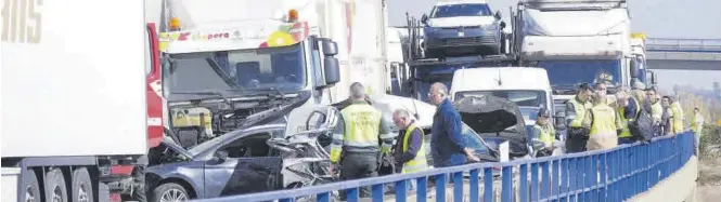  ?? MÓNICA MIRA ?? Agentes de la Guardia Civil y algunos de los afectados por el choque múltiple, junto a varios de los vehículos siniestrad­os ayer por la mañana en la autopista, a la altura de Nules.