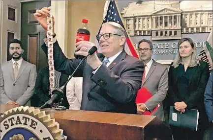  ?? DON THOMPSON Associated Press ?? AT A CAPITOL news conference, state Sen. Bill Monning (D-Carmel) illustrate­s the amount of sugar in a typical soft drink while discussing a package of five bills aimed at discouragi­ng consumptio­n of sugary beverages. He doesn’t accept soda industry money.