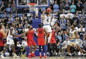  ?? DAVID JABLONSKI / STAFF ?? Dayton’s Josh Cunningham takes a charge against Rhode Island’s Tyrese Martin on Saturday at the Ryan Center in Kingston, R.I.