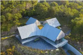  ??  ?? ABOVE LEFT: Each of the house’s wings, which are capped by gabled zinc roofs, has a distinct role: kitchen, living room, master suite, bedrooms.