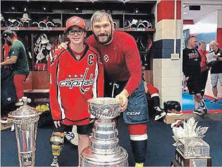  ?? SPECIAL TO THE NIAGARA FALLS REVIEW ?? Niagara Falls teenager and cancer survivor Alex Luey celebrates with his hero, Washington Capitals superstar and captain Alex Ovechkin, with the Stanley Cup in the team’s locker room before taking in the club’s victory parade on Tuesday.