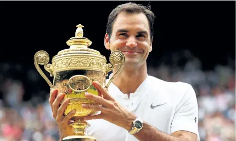  ?? CLIVE BRUNSKILL/GETTY IMAGES ?? Roger Federer celebrates victory with the trophy after the Gentlemen’s Singles final against Marin Cilic on Day 13 of the Wimbledon Lawn Tennis Championsh­ips at the All England Lawn Tennis and Croquet Club at Wimbledon on Sunday, in London, England.