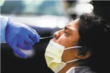  ?? Gabrielle Lurie / The Chronicle ?? Dr. Marco Reyes gives Marta Munoz a COVID19 test last month at Southeast Health Center in San Francisco.