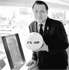  ??  ?? Kozo Tashima poses with a soccer ball after an interview with Reuters at his office in Tokyo, Japan. — Reuters photo