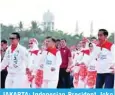  ?? — AFP ?? JAKARTA: Indonesian President Joko Widodo and Vice President Yusuf Kalla take part in a mass dance through the streets of Jakarta to promote the Asian Games yesterday.