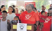  ?? CAROLINE BAUMAN/
CHALKBEAT ?? Memphis Lift advocates talk about their mission to educate, engage and empower parents regarding education issues. In the background are signs protesting the state-run Achievemen­t School District.